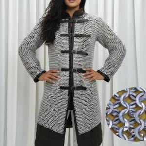 May include: A silver chainmail coat with black leather trim and buckles. The long-sleeved coat has a high collar and is knee-length. A close-up shows the interlocking metal rings of the chainmail.