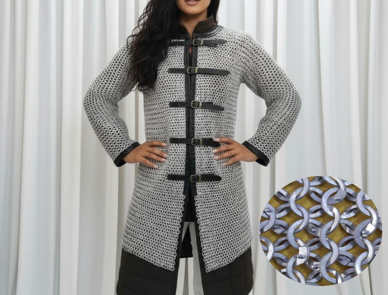 May include: A silver chainmail coat with black leather trim and buckles. The long-sleeved coat has a high collar and is knee-length. A close-up shows the interlocking metal rings of the chainmail.