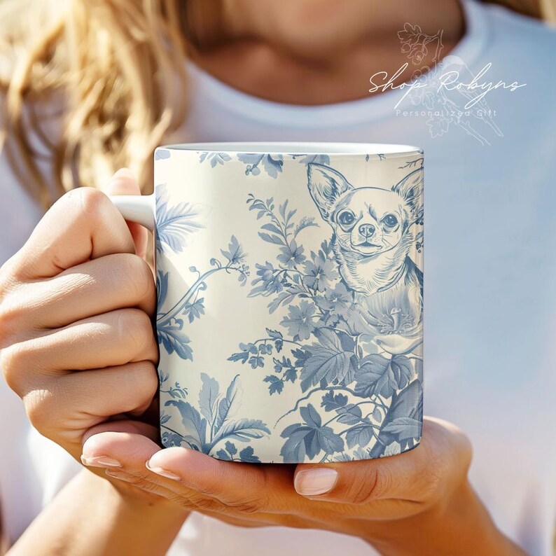 Pu&ograve; includere: Tazza in ceramica bianca con un motivo toile de Jouy blu e bianco e un'illustrazione di Chihuahua. La tazza presenta un motivo floreale e il testo "Shop Robyn's Personal Gift".