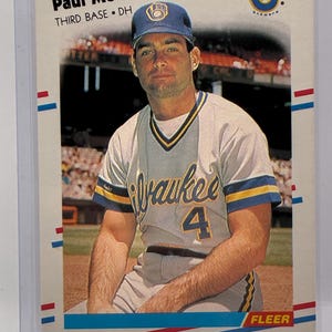 May include: A 1988 Fleer baseball card featuring Paul Molitor of the Milwaukee Brewers. The card displays the player in a grey uniform with blue and yellow trim, wearing a blue cap with the Brewers logo. Text includes Paul Molitor, Third Base, DH.