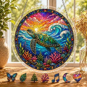 May include: A round, stained-glass window featuring a sea turtle swimming in a vibrant ocean scene. The artwork includes a colorful sunset, waves, and coral. A chain is attached for hanging. Decorative pins of a butterfly, leaf, tree, coral, musical note, moon, and heart are displayed below.