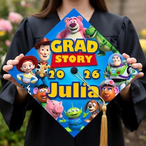 May include: A blue graduation cap featuring characters from the animated film Toy Story. The cap has the words "GRAD STORY 2026 Julia" in yellow and white. The cap is decorated with images of Woody, Buzz Lightyear, and other characters.