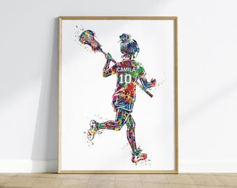 May include: Watercolor print of a lacrosse player in action, wearing a jersey with "CAMILA" and the number "10". The artwork features a vibrant, multi-colored splatter effect, set against a white background, and framed in a light wood frame.