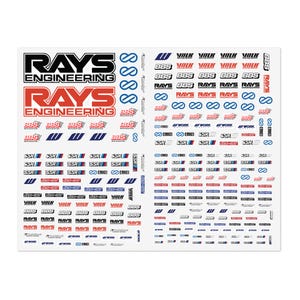 May include: A large decal sheet featuring numerous automotive brand logos including RAYS Engineering, BBS, Volk Racing, Enkei, SSR, and Work Wheels. The stickers are printed in black, red, and blue on a white background in various sizes.