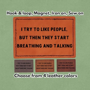 Könnte beinhalten: Orangenes Lederpatch mit dem Text "I TRY TO LIKE PEOPLE, BUT THEN THEY START BREATHING AND TALKING." Das Bild zeigt auch drei kleinere Patches und den Text "Choose from 4 leather colors."