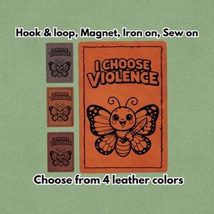 Op de afbeelding: Oranje leren patch met de tekst "I Choose Violence" en een cartoonvlinder met een mes. Drie kleinere patches met hetzelfde vlinderontwerp en tekst worden weergegeven. De tekst "Choose from 4 leather colors" is ook aanwezig.