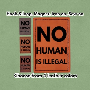 May include: An orange leather patch with the words "NO HUMAN IS ILLEGAL" in black. Three smaller patches with the same text are displayed. The text "Choose from 4 leather colours" is also present.