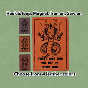 Könnte beinhalten: Orangefarbener Lederaufnäher mit schwarzem Drachenmotiv, der zwei Pistolen hält, und dem Text "THERE'S MORE THAN ONE WAY TO OTHER WORLD." Enthält drei kleinere Aufnäher. Erhältlich in 4 Lederfarben.