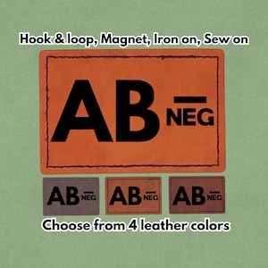 May include: An orange leather patch with the text "AB NEG" in black. The patch is rectangular with a stitched border. Below are three smaller patches in different shades of brown, each with the same text. Text at the top says "Hook & loop, Magnet, Iron on, Sew on".