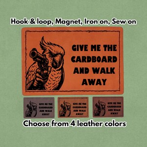 May include: Orange rectangular patch with a black illustration of a bird holding a gun, with the text "GIVE ME THE CARDBOARD AND WALK AWAY." Below are three smaller patches in different colors. The text "Choose from 4 leather colors" is at the bottom.