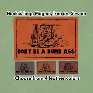 Könnte beinhalten: Orangenes Lederpatch mit einem Cartoon-Esel, der einen Gabelstapler fährt, und dem Text "DON'T BE A DUMB ASS". Erhältlich in vier Lederfarben, kann mit Klettverschluss, Magnet, zum Aufbügeln oder Aufnähen befestigt werden.