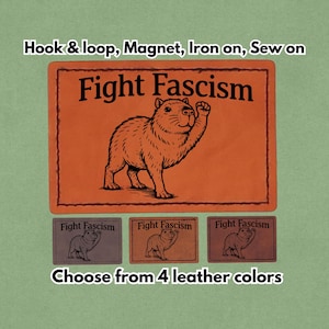 May include: Orange patch with a capybara illustration and the text "Fight Fascism." Includes options for hook & loop, magnet, iron-on, or sew-on. Available in four leather colors.