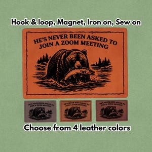 May include: An orange patch featuring a bear catching a fish, with the text "HE'S NEVER BEEN ASKED TO JOIN A ZOOM MEETING". Below, three smaller patches in different colours with the same design. Text reads "Choose from 4 leather colours".