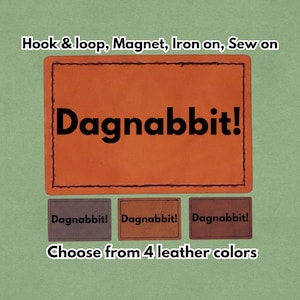 Op de afbeelding: Oranje leren patch met het woord "Dagnabbit!" in zwarte letters. De patch is verkrijgbaar in vier kleuren leer en kan worden bevestigd met klittenband, magneet, opstrijkbaar of opgenaaid.