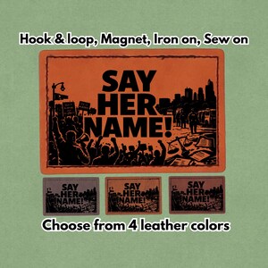 Puede incluir: Parche naranja y negro con el texto "SAY HER NAME!" y una ilustración de una escena de protesta. Debajo, tres parches más pequeños en diferentes colores con el mismo texto y diseño. La imagen también incluye el texto "Hook & loop, Magnet, Iron on, Sew on" y "Choose from 4 leather colors."
