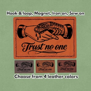 May include: Rectangular leather patches with a hand and snake illustration, and the text "Trust no one." The patches are available in four colors. The image also shows the options: hook & loop, magnet, iron on, and sew on.