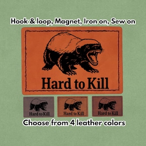 Könnte beinhalten: Rechteckige Aufnäher mit einer schwarz-weißen Illustration eines knurrenden Tieres und dem Text "Hard to Kill". Die Aufnäher sind in vier Lederfarben erhältlich und können mit Klettverschluss, Magnet, zum Aufbügeln oder zum Aufnähen befestigt werden.