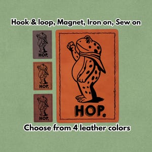 May include: An orange leather patch featuring a black frog design and the word "HOP." Three smaller brown leather patches are also shown. The text "Hook & loop, Magnet, Iron on, Sew on" and "Choose from 4 leather colours" are included.