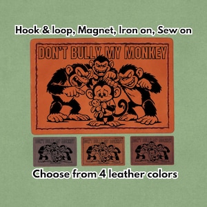 May include: Orange leather patch featuring the phrase "DON'T BULLY MY MONKEY" and a monkey cartoon design. Available in four leather colours, it can be attached using hook and loop, magnet, iron-on, or sewn on.