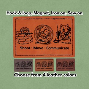 Può includere: Toppa in pelle arancione con tre criceti dei cartoni animati in pose militari, con la scritta "Shoot Move Communicate". La toppa è disponibile in quattro colori di pelle e può essere applicata con velcro, magnete, termoadesivo o cucito.
