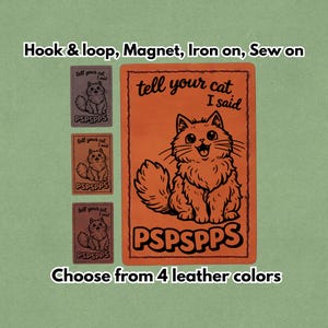 Può includere: Toppa in pelle arancione con un'illustrazione di un gatto dei cartoni animati e il testo "tell your cat I said" e "PSPSPPS". L'immagine mostra anche tre toppe più piccole in diversi colori. È presente anche il testo "Choose from 4 leather colors".