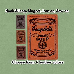 Könnte beinhalten: Ein orangefarbener und schwarzer Lederaufnäher mit dem Design der Campbell's Tomato Soup Dose. Der Text lautet "Campbell's Tomato Soup" und "Made by Poor People for Poor People". Erhältlich in vier Lederfarben.