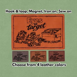 Peut inclure: Un patch en cuir orange avec le texte "Eyes on target" et une illustration de ratons laveurs en tenue militaire visant une benne à ordures. En dessous, trois petits patchs de couleurs différentes. Le texte "Hook & loop, Magnet, Iron on, Sew on" est au-dessus.