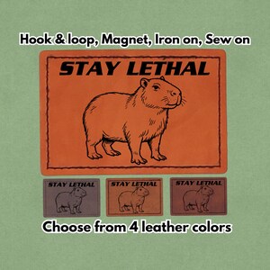 May include: Orange leather patch with a capybara illustration and the text "STAY LETHAL." Includes options for hook & loop, magnet, iron-on, or sew-on. Available in four leather colors.