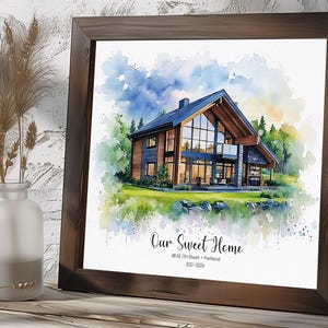 May include: Watercolor print of a modern house with a dark wood frame. The artwork features a house with large windows, surrounded by trees and a blue sky. Text reads "Our Sweet Home" and address.