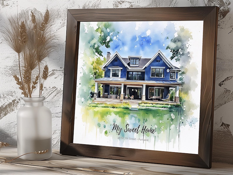 May include: A framed watercolor print of a blue house with a white porch, surrounded by green trees and grass. The print is in a dark brown wooden frame. The text "My Sweet Home" and address are at the bottom of the print.