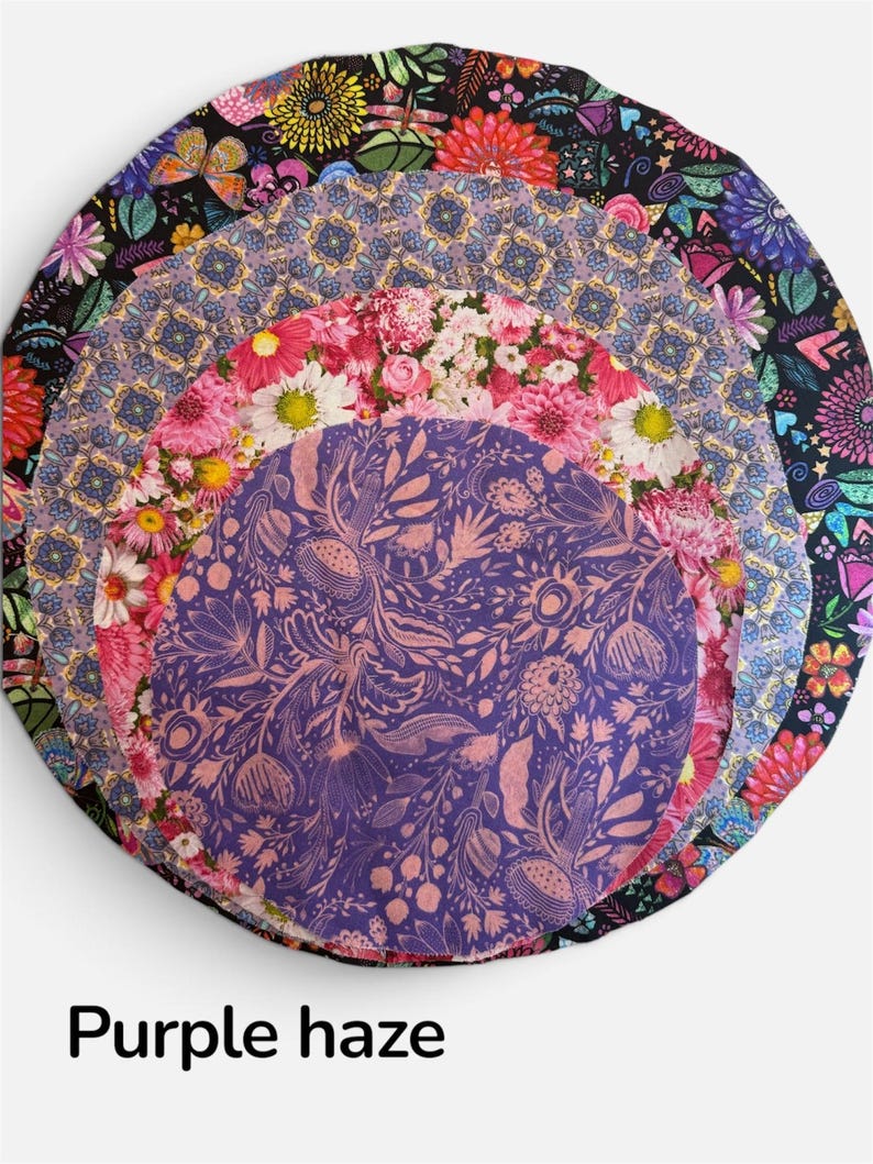 K&ouml;nnte beinhalten: Ein Stapel aus vier runden Stoffabdeckungen mit verschiedenen Mustern, darunter ein schwarzer Hintergrund mit bunten Blumen, ein violetter geometrischer Druck, ein rosa Blumenmuster und ein violetter Stoff mit botanischem Druck, beschriftet mit Purple haze.