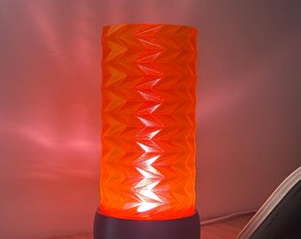 Lámpara geométrica translúcida de color naranja impresa en 3D