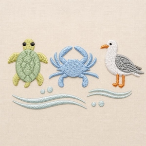 Könnte beinhalten: Gesticktes Design mit maritimem Thema, einschließlich einer grünen Schildkröte, einer blauen Krabbe und einer weißen Möwe mit grauen Flügeln. Hellblaue Wellen und Blasen sind ebenfalls vorhanden, vor einem beigen Hintergrund. Das Design erinnert an eine nautische Ästhetik.