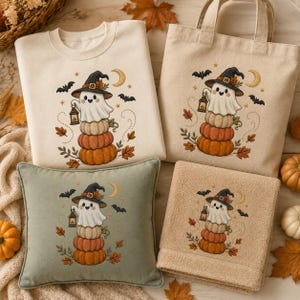 May include: A cream sweatshirt, a cream tote bag, a sage green pillow, and a tan towel, each featuring an embroidered design of a ghost wearing a witch hat, holding a lantern, and sitting on a stack of three pumpkins with bats, leaves, and a moon.