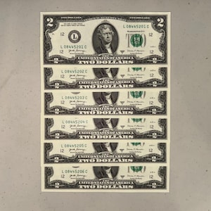 K&ouml;nnte beinhalten: Ein vertikaler Stapel von sechs Zwei-Dollar-Scheinen der Vereinigten Staaten, die jeweils ein Portr&auml;t von Thomas Jefferson, den Text 'THE UNITED STATES OF AMERICA', 'TWO DOLLARS' und fortlaufende Seriennummern von L08445201C bis L08445206C zeigen.