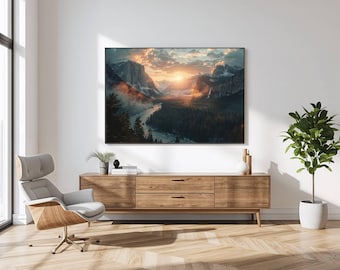 May include: A large framed landscape art print depicting a mountain valley scene with a river, forest, and sunset. The artwork is displayed above a wooden cabinet with drawers. A modern gray chair and a potted plant are in the room.