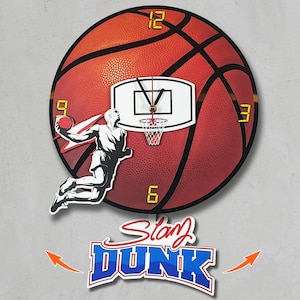 May include: A basketball-themed wall clock featuring a red basketball design with black lines. The clock has a basketball hoop and a player in mid-air, about to dunk the ball. The clock hands are black. The words "Slam Dunk" are below the clock.