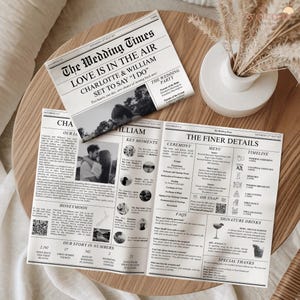 May include: Wedding newspaper with the headline "The Wedding Times" and the text "Love is in the Air." The newspaper includes photos, key moments, ceremony details, and a timeline. The newspaper is on a wooden table.