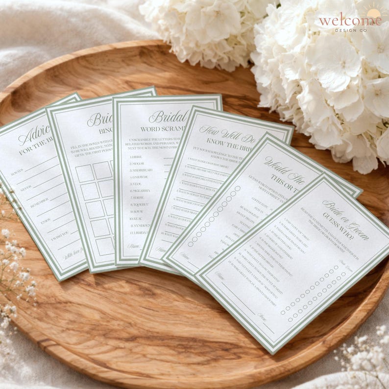 Op de afbeelding: Een set van vijf rechthoekige witte spelkaarten voor een bruidsdouche met saliegroene randen en zwarte tekst. De kaarten bevatten titels zoals Advice for the Bride, Bridal Bingo, Word Scramble, How Well Do You Know the Bride en Would She Rather.
