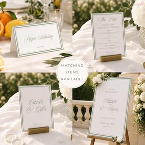 Op de afbeelding: Een set witte trouwkaarten en bordjes met saliegroene dubbele lijnen en elegante schreefletters. De set bevat een naamkaartje voor Pippa Halliday, een barmenu, een bordje voor kaarten en cadeaus en een groot welkomstbord voor een bruiloft.