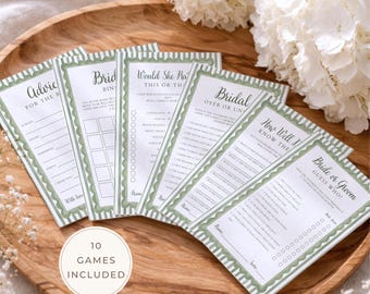 Op de afbeelding: Een verzameling van tien spelkaarten voor een bruidsdouche met groen-witte decoratieve randen. De kaarten zijn gerangschikt op een houten dienblad, met teksten als "Advies voor de bruid" en "Bruid of bruidegom". Een wit bloemstuk staat op de achtergrond.