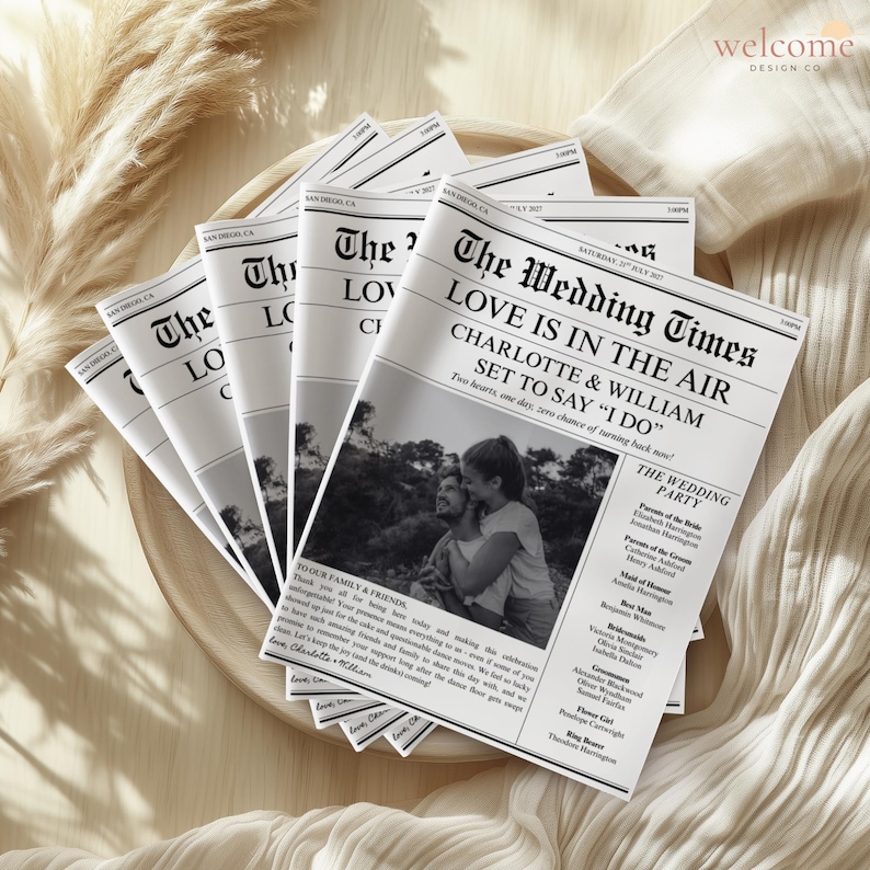 May include: A stack of wedding newspaper-style announcements. The headline reads "The Wedding Times" with the names "Charlotte & William" and the phrase "Love is in the Air." A black and white photo of the couple is featured.