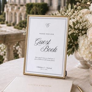 May include: A gold-framed sign with white paper featuring black text that reads: Please sign our Guest Book, Pick a page & leave us a kind note or piece of advice we will treasure forever, Madeleine & Frederick, May 21, 20XX, and the initials MF.