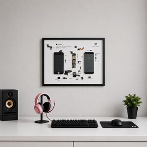 May include: A framed wall art display featuring a deconstructed iPhone 5 with its internal components laid out on a white background. The display includes the front and back of the phone casing, various internal parts, and text labels.