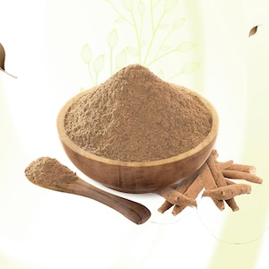 May include: A wooden bowl filled with brown powder, a wooden spoon with powder, and several brown sticks. The items are set against a soft, light green background with leaf-like designs. The powder appears finely ground.