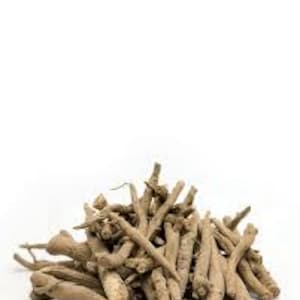 Puede incluir: Un mont&oacute;n de ra&iacute;ces secas de ashwagandha, de color marr&oacute;n claro, sobre un fondo blanco. Las ra&iacute;ces, de tama&ntilde;os y formas variadas, presentan un aspecto rugoso y texturizado. La imagen est&aacute; bien iluminada, resaltando el color natural y los detalles.