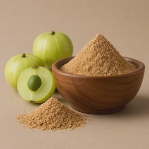 Puede incluir: Imagen de naturaleza muerta con grosellas verdes, una cortada por la mitad, y un cuenco de madera lleno de polvo marrón. Un pequeño montón de polvo está delante del cuenco. El fondo es beige neutro.