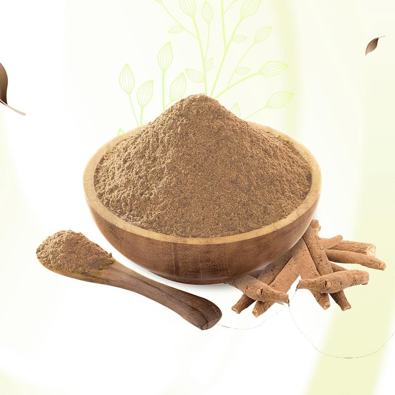 Peut inclure: Un bol en bois rempli de poudre brune, une cuill&egrave;re en bois avec de la poudre et plusieurs b&acirc;tonnets bruns. Les articles sont plac&eacute;s sur un fond vert clair et doux avec des motifs en forme de feuilles. La poudre semble finement moulue.