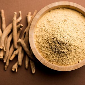 Peut inclure: Un bol en bois rempli d'une poudre brun clair est plac&eacute; &agrave; c&ocirc;t&eacute; d'un tas de racines s&eacute;ch&eacute;es de couleur beige. Les &eacute;l&eacute;ments sont dispos&eacute;s sur une surface brune. La poudre semble finement moulue et les racines ont une texture rugueuse.
