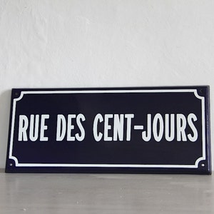 May include: A blue and white enamel street sign with the text "RUE DES CENT-JOURS" in white lettering.